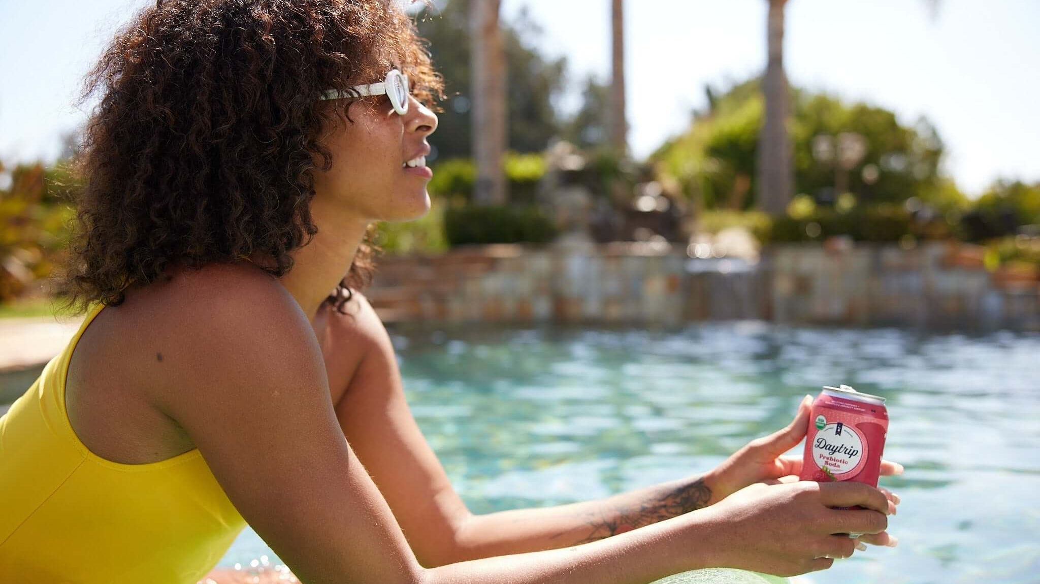 beautiful african american model enjoying a daytrip organic prebiotic soda poolside