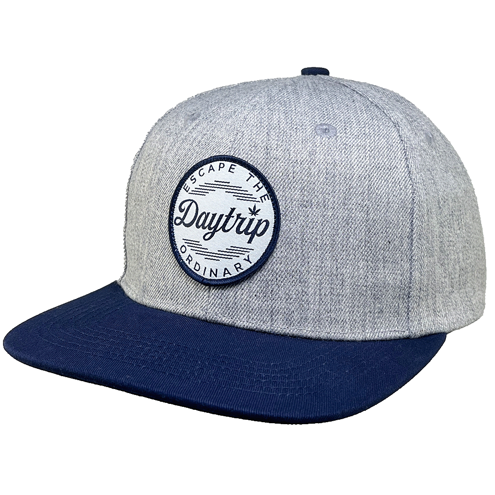 Daytrip Escape the Ordinary snapback cap in heather grey with navy bill and round Daytrip Escape The Ordinary woven patch