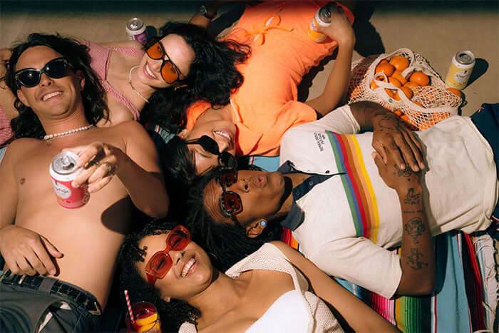 A group of stylish 20-something friends lying down and relaxing with Daytrip CBD infused sparkling water
