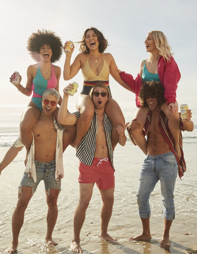a group of stylish young revelers partying on the beach